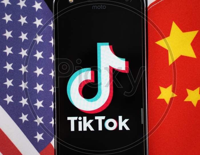 Maski, India 04, August 2020 - Tiktok App Logo On A Smartphone Screen In Between China And United States - The App Is In Centre Of Us - China Trade Tensions And Security Concerns.