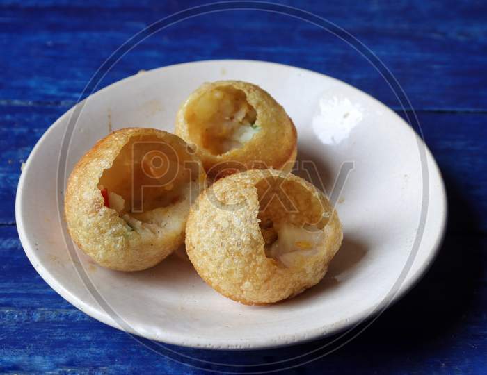 Close Up Of Panipuri Or Golgappa In A Plate Isolated On Blue Wooden Background, Also Known As Phuchka, Paani Patashi, Gol Gappa, Gup Chup