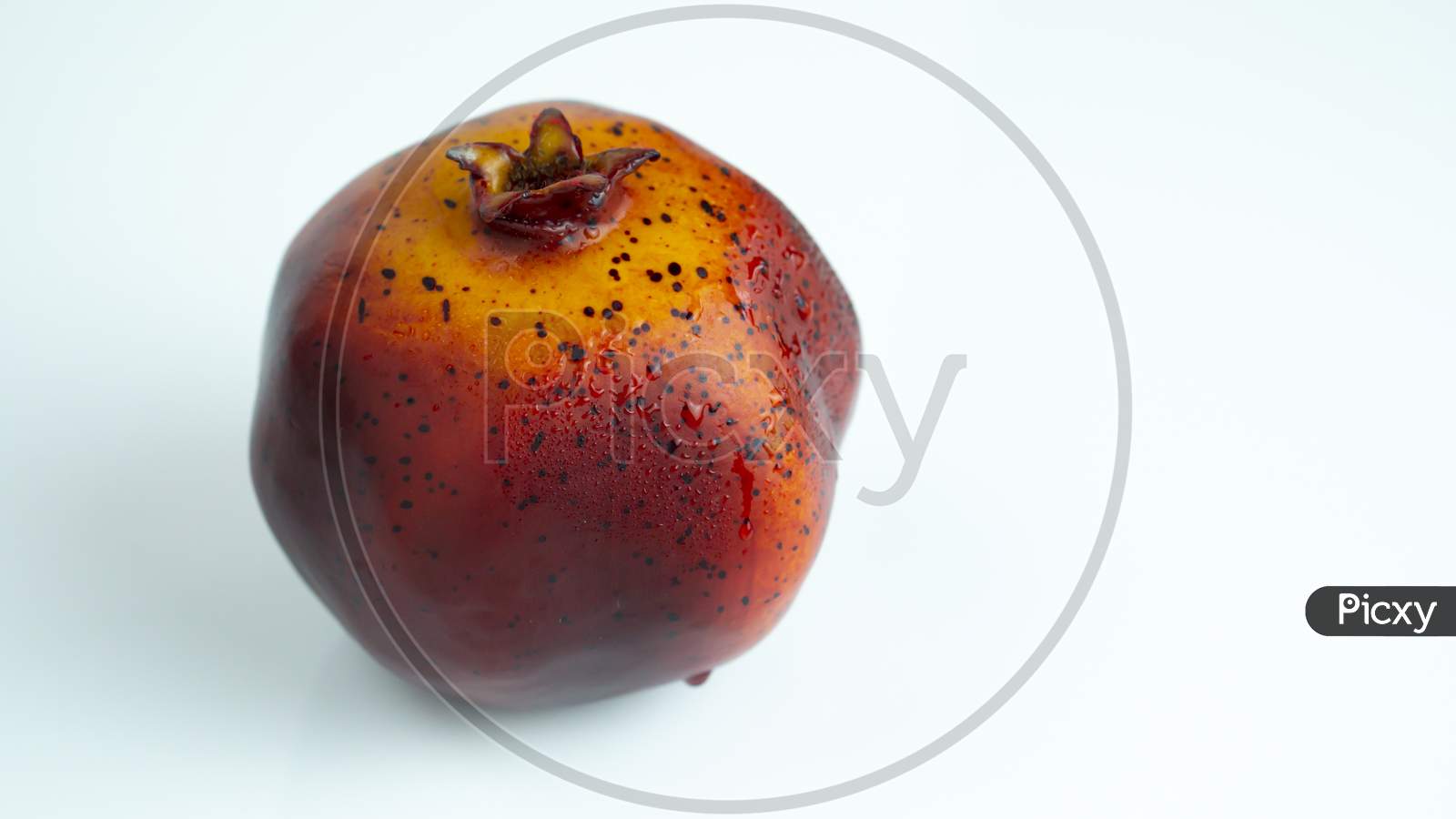 Beautiful whole artificial pomegranate on a isolated white background