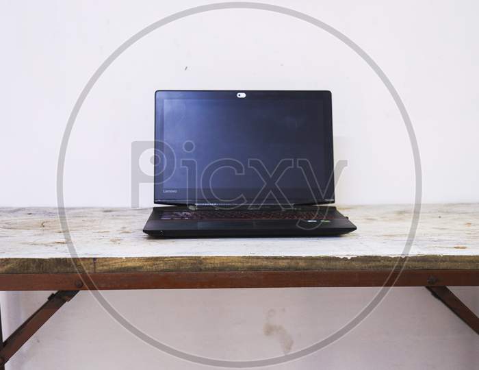 Black Laptop On A Wooden Table 1