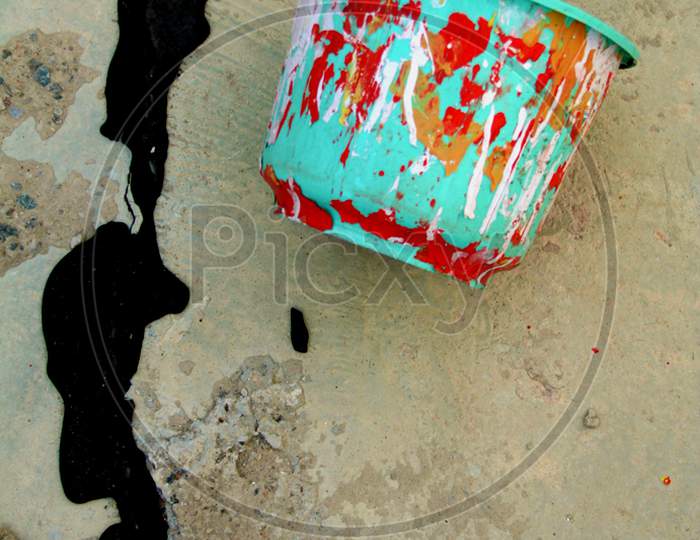Colorful Bucket With Black Paint On Ground