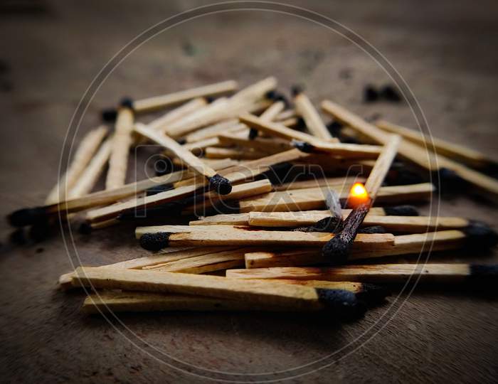 Burning matchstick on top of exhausted matchsticks