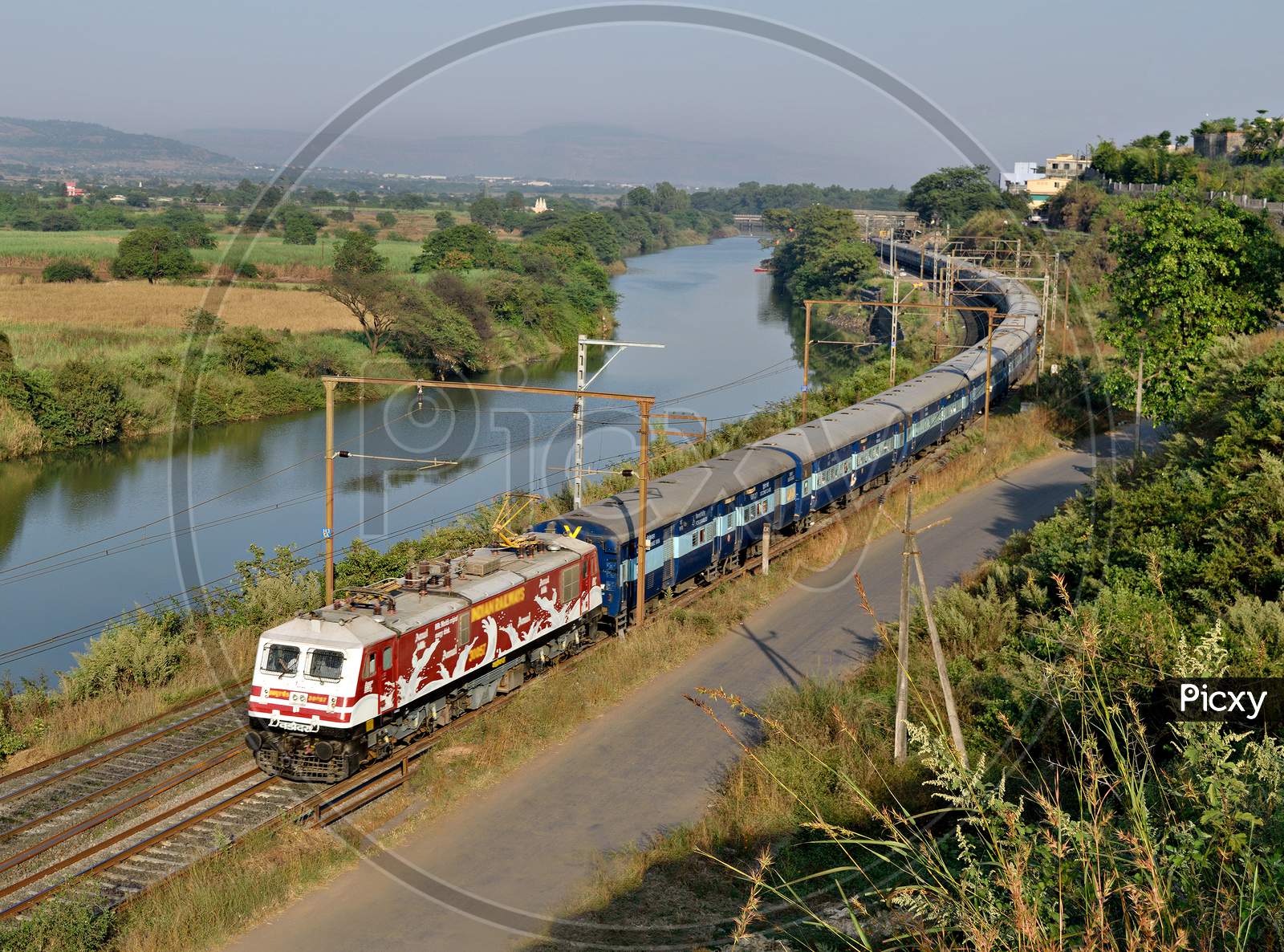 Amul Milk advertised locomotive with Indore express running parallel to a river Indrayani through Kamshet, India.