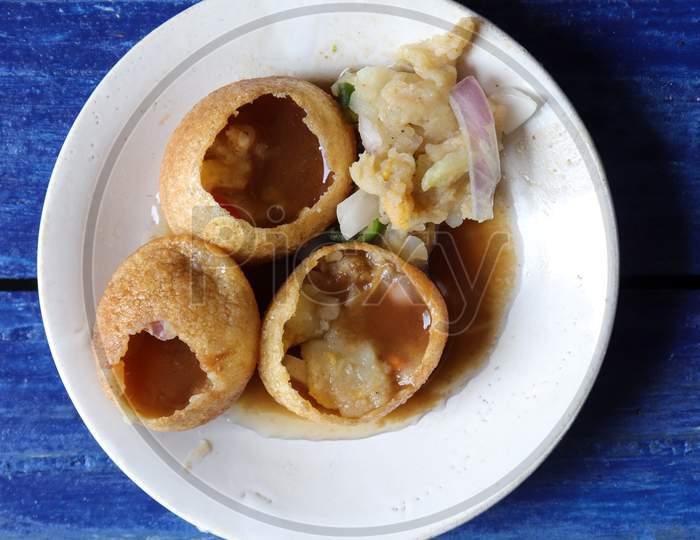 Top View Of Panipuri Or Golgappa In A Plate Isolated On Blue Wooden Background, Also Known As Phuchka, Paani Patashi, Gol Gappa, Gup Chup