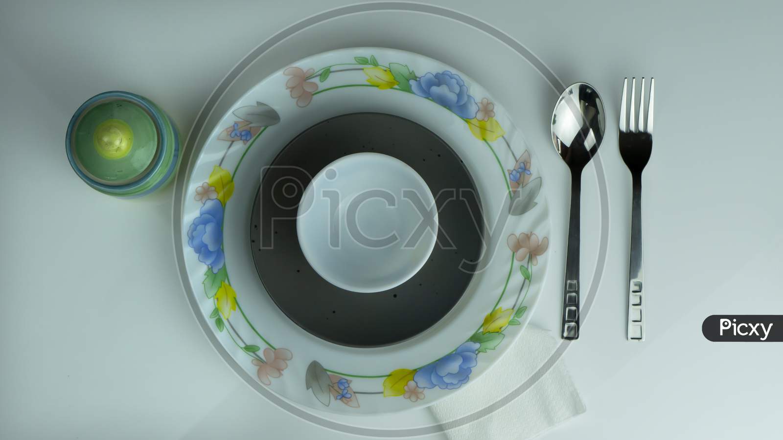 Top view of dinner plate with utensils on white background