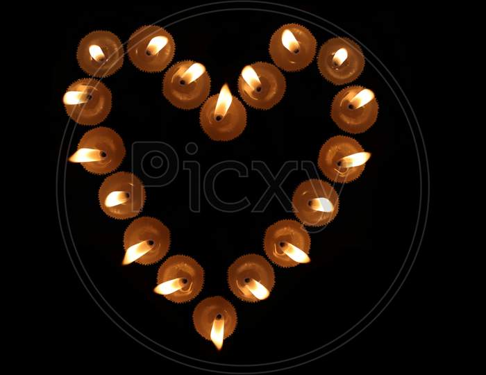 Heart Shape Created Burning Candles In Black Background, Perfect For Wallpaper