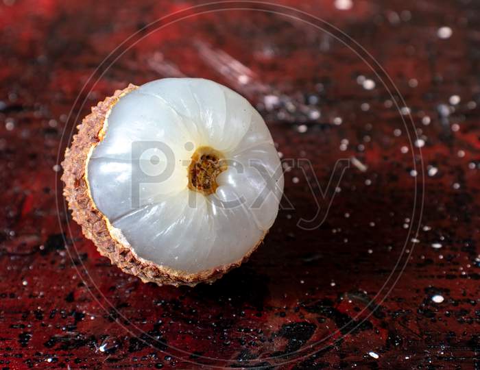 Peeled Lychee Or Litchi With Selective Focus Isolated On Reddish Background With Copy Space