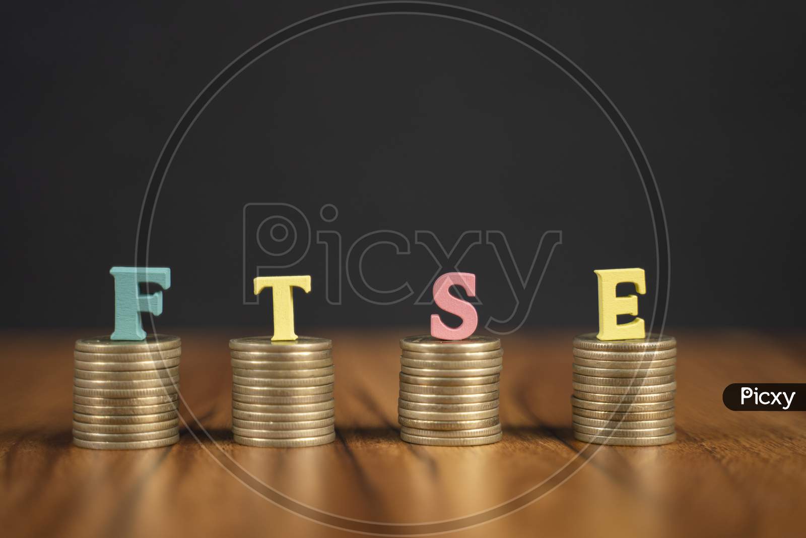 Concept Of Ftse Or Financial Times Stock Exchange Showing With Coins And Letters On Black Background.