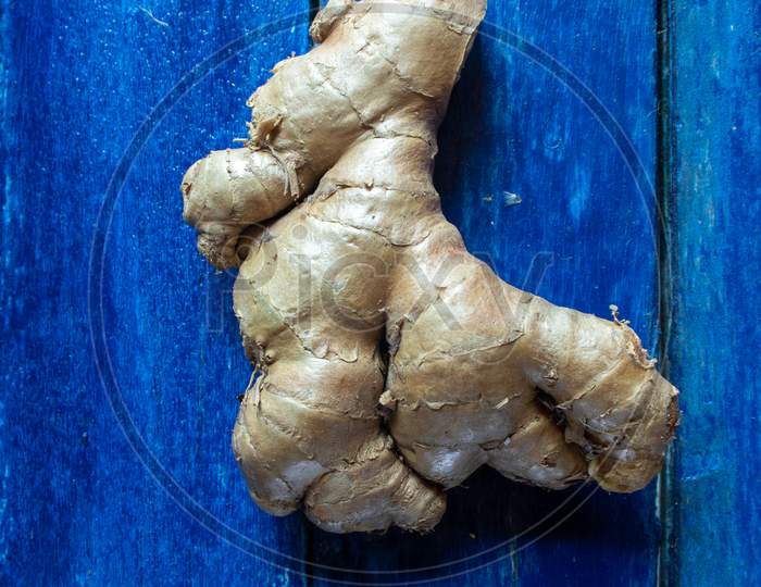 Organic Ginger Root Isolated On Wooden Background In Vertical Orientation