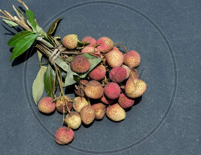 Organic Litchi Or Lychee Cluster With Leaves Isolated On Black Bckground