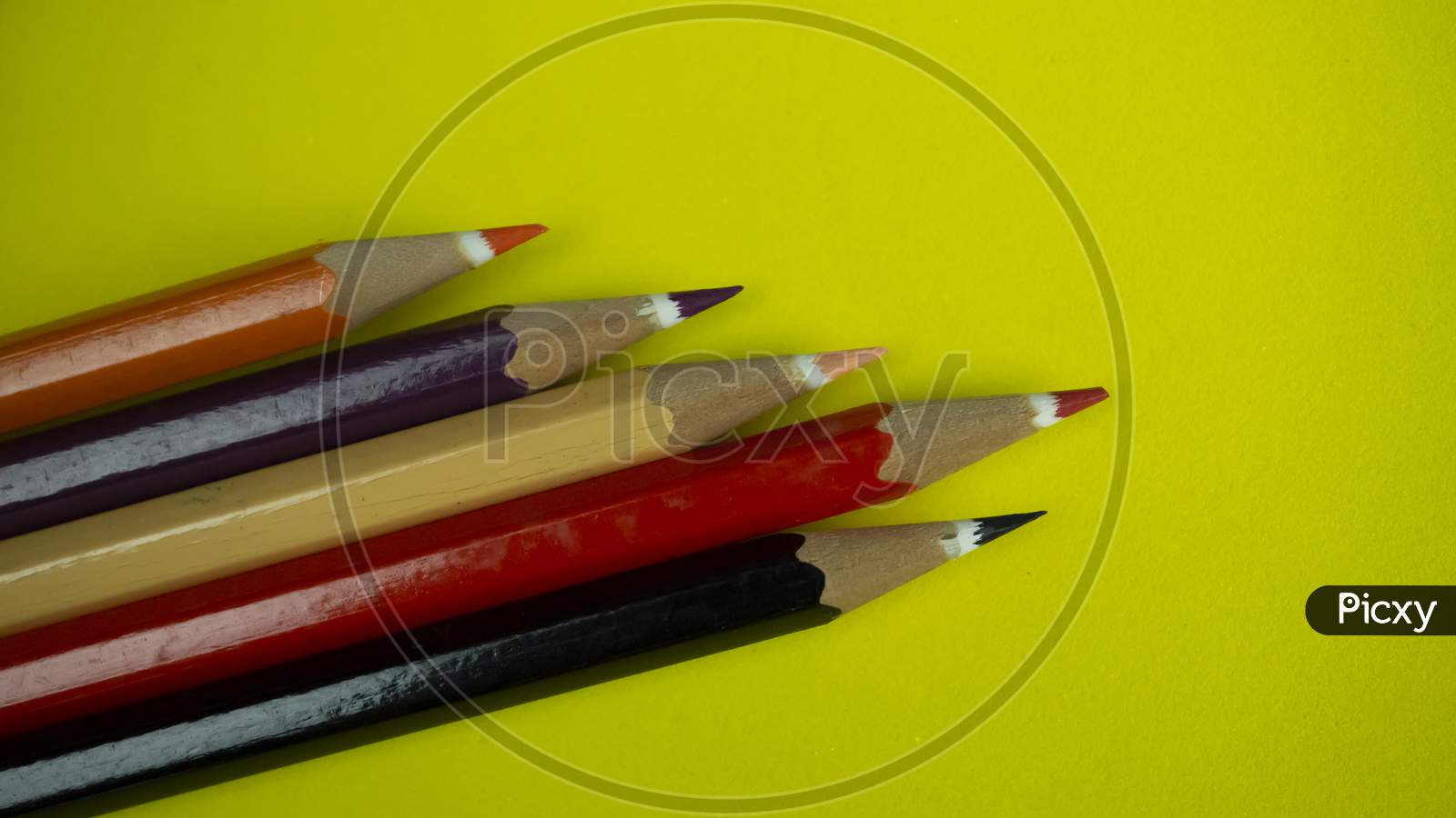 Color pencils are kept together on bright yellow background