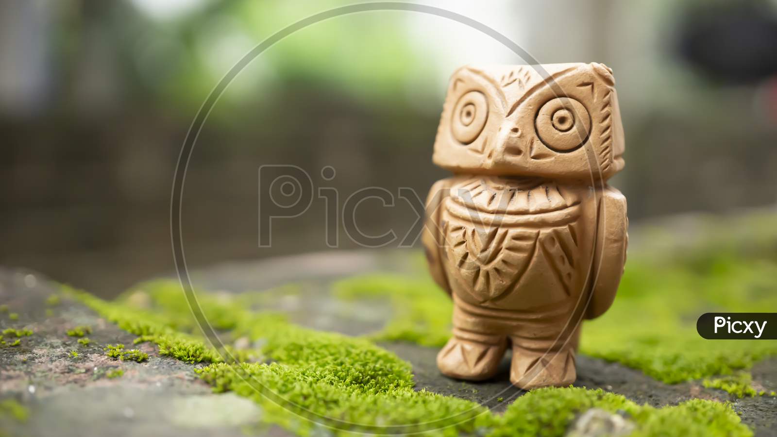 Terracotta owl on a moist background