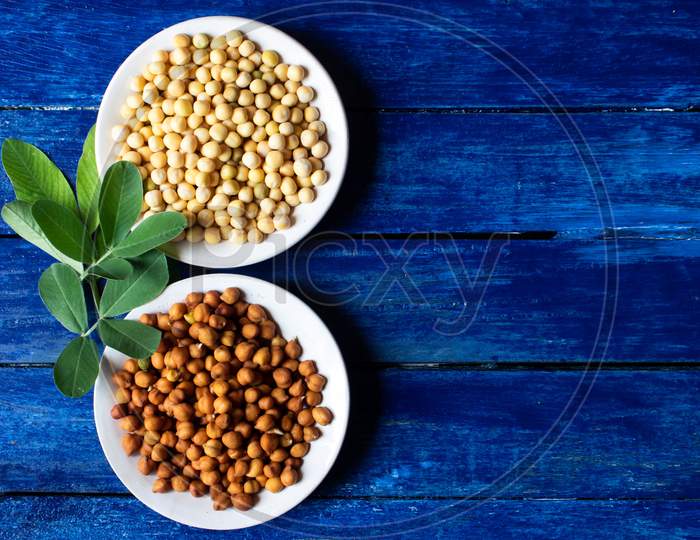 Wet Chickpea And Pea Seeds In Plates Isolated On Blue Colored Wooden Background With Copy Space