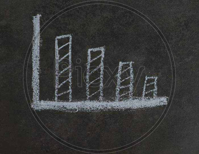 Falling Or Decreasing Graph Drawn With White Chalk On Black Surface, Economic Crisis Conceptual Photo