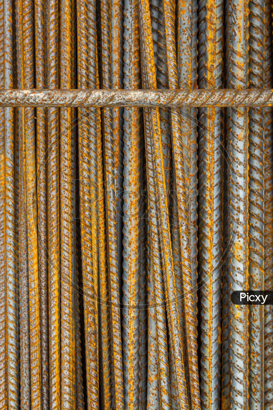 Rusty Steel Rods. Material For The Construction Of Buildings And Houses. Strong Metallic Material Forming A Repeating Pattern