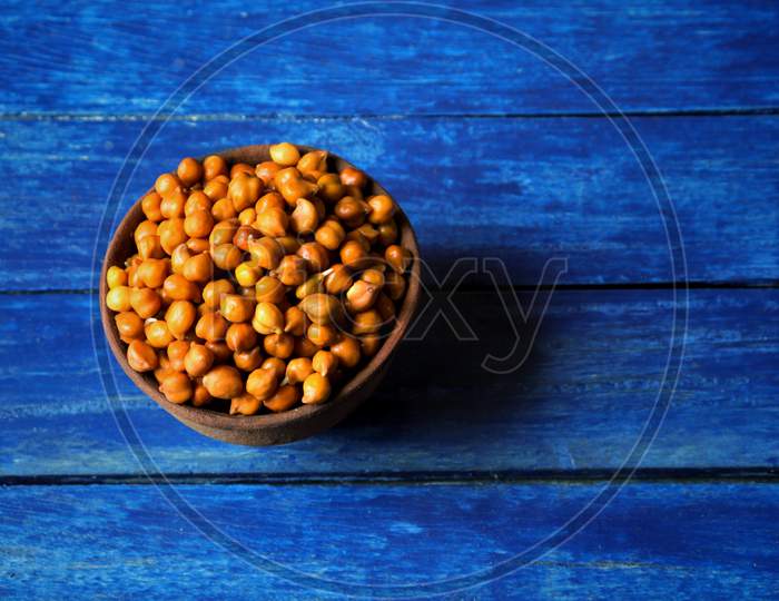 Wet Chickpea Or Garbanzo Bean In A Clay Bowl Isolated On Blue Colored Wooden Background With Copy Space