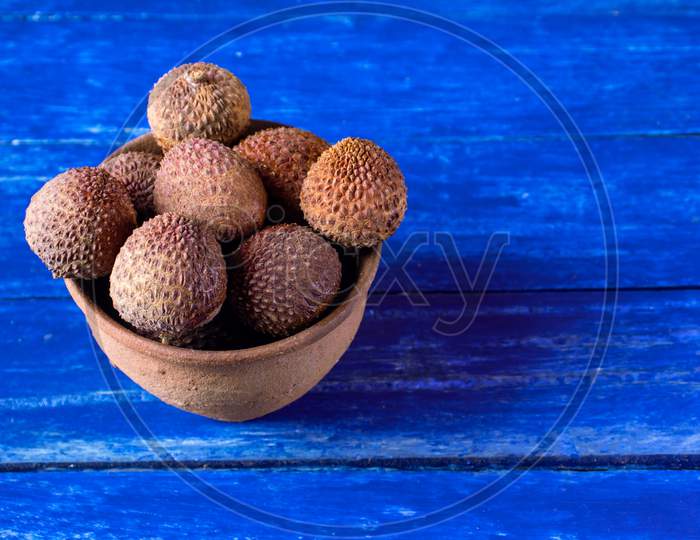 Lychee Or Litchi Fruits In A Clay Bowl Isolated On Wooden Background With Copy Space For Texts Writing