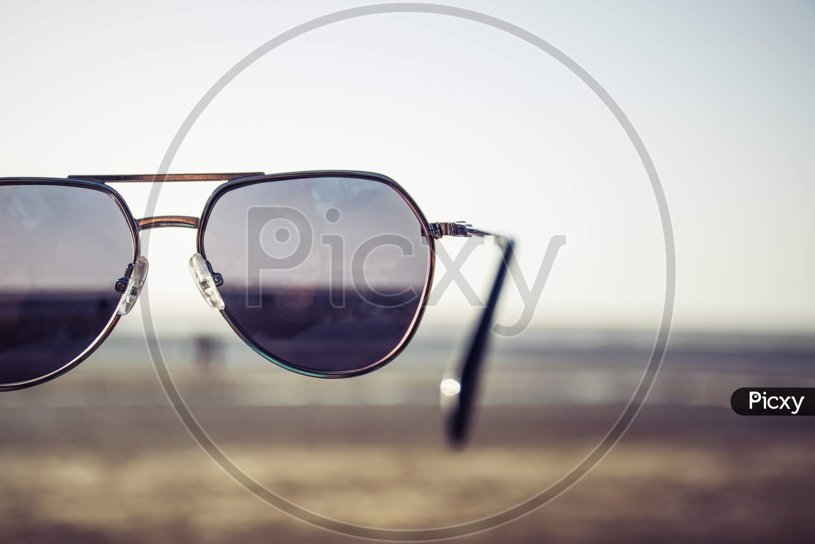 Retro Themed Sunglasses Held In Air At Jampore Beach Of Daman In India