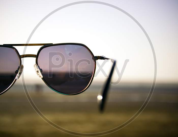 Retro Themed Sunglasses Held In Air At Jampore Beach Of Daman In India