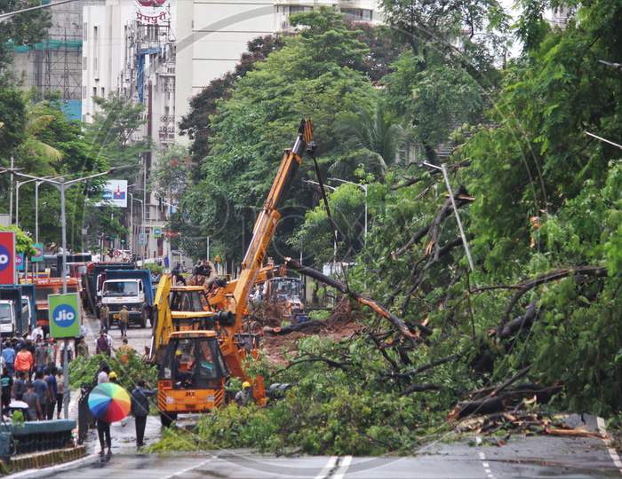 Firefighters and other workers clear debris from a landslide after heavy rainfall in Mumbai, India on August 6, 2020.