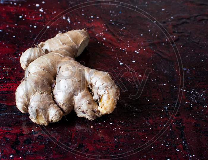 Organic Ginger Root Isolated On Reddish Background With Copy Space