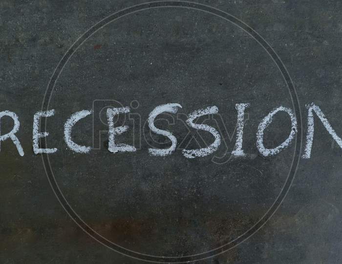 Recession Word Written On Black Surface With White Chalk