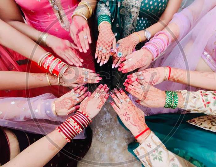Friends hands with fashion accessories and mehndi.
