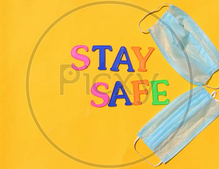 Medical Face Masks With Stay Safe Message Isolated On Yellow Background With Copy Space