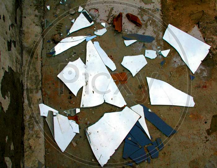Close-Up Shards Of Broken Mirror On Stone Floor