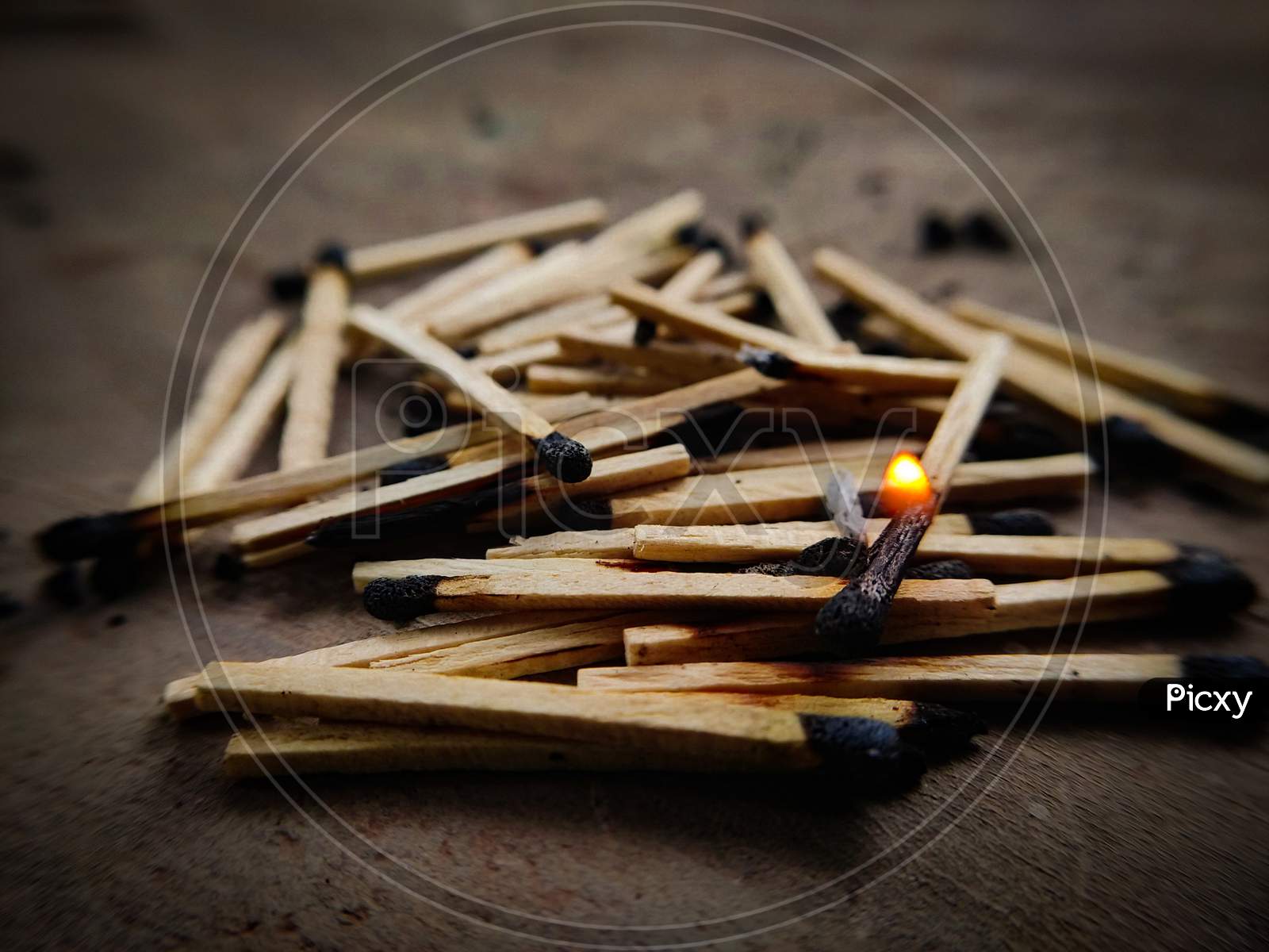 Burning matchstick on top of exhausted matchsticks