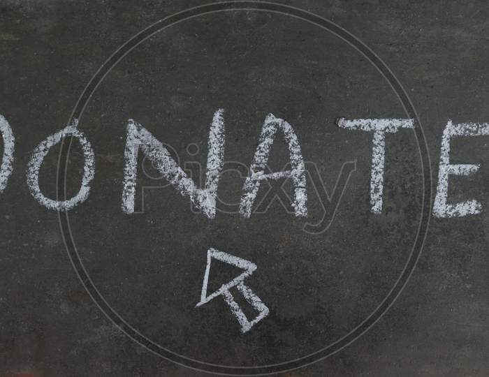 Donate Word Written On Black Surface With White Chalk
