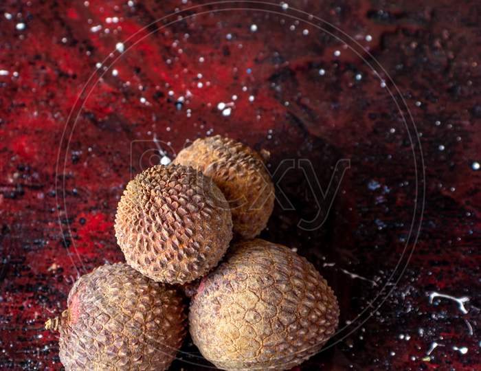 Ripe Lychee Or Lichi Isolated On Reddish Background In Vertical Orientation