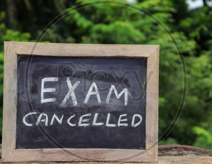 Exam Cancelled Phrase Written On Chalkboard With White Chalk