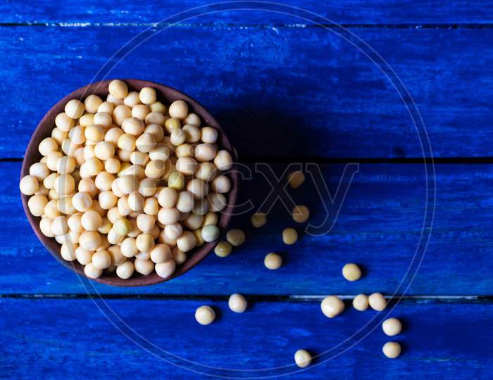 Wet Pea Seeds In A Clay Bowl Isolated On Blue Wooden Background With Copy Space