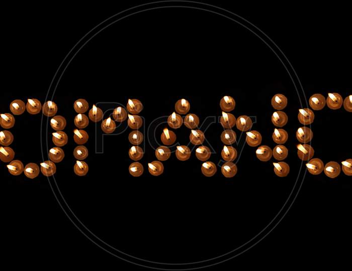 Romance Word Written With Burning Candles In Black Background