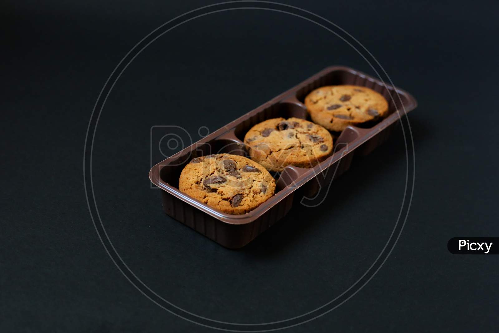 Chocolate Chip Cookies Isolated On Black Background. Chocolate cookies on black background. Chocolate chip cookie on black background with copy space for text, closeup.