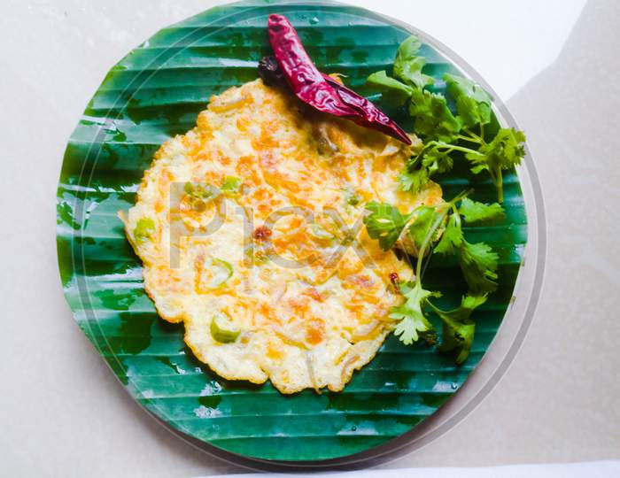 Egg Omelette With Coriander Leaves And Red Chillies In A Banana Leaf
