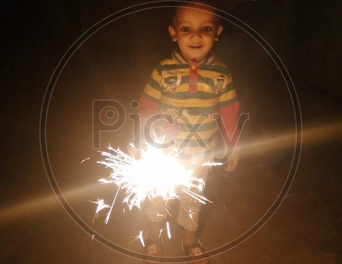 A little kid playing with sparkler