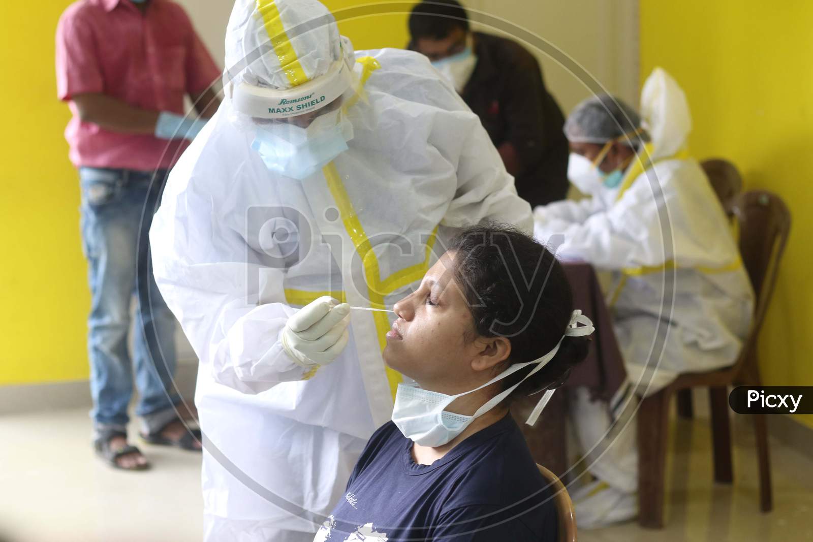 A healthcare worker collects samples from a person for Covid -19 antigen testing amid the complete bi-weekly lockdown to curb Coronavirus spread in Kolkata on August 8, 2020