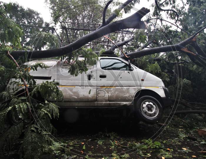 A vehicle gets damaged after an uprooted tree fell on it, after strong winds and heavy rainfall in Mumbai, India on August 6, 2020.