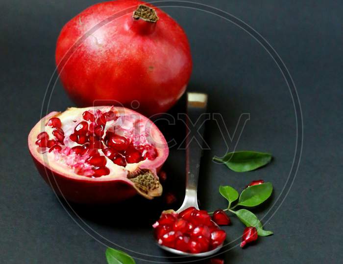 Ripe Pomegranate With Leaves On A Dark Background
