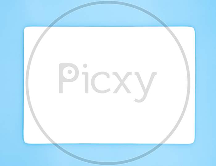 A Rectangle Empty White Plate Isolated On The Light Blue Background.