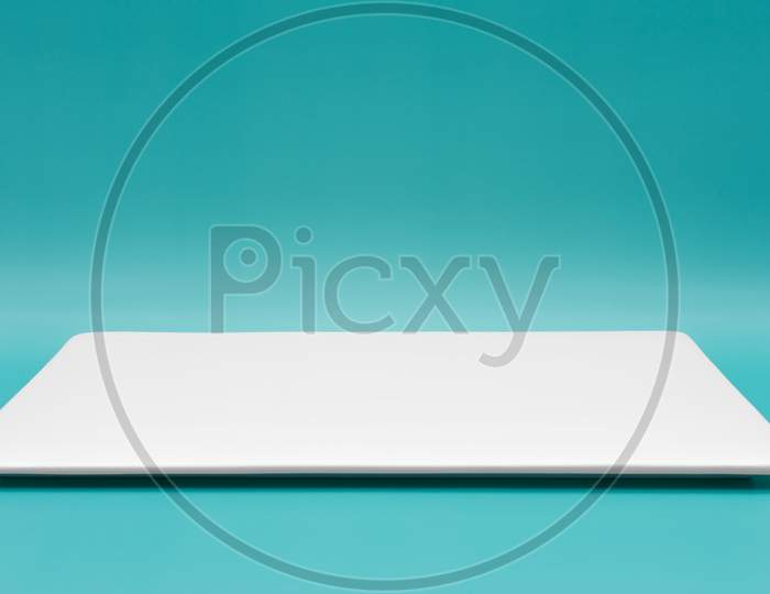 A Rectangle Empty White Plate Isolated On The Tiffany Blue Background.