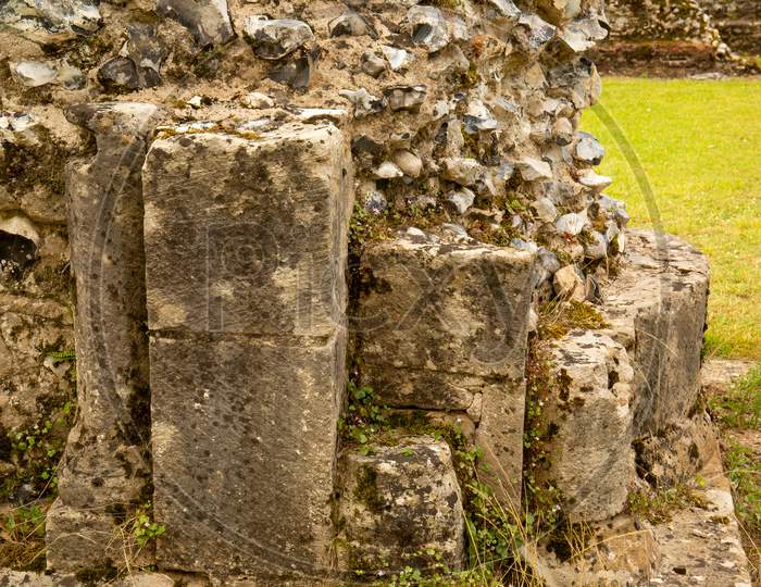 Sandstone Columns In Medieval Flint Stone Wall Ruins.