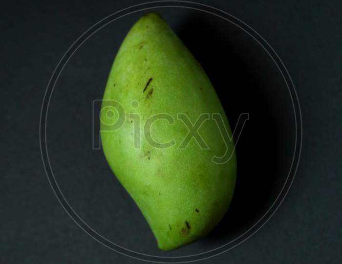 Green Mango Isolate On Dark Background. Big Green mango.