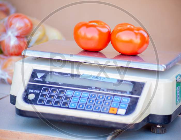 A Red Ripe Tomatoes On A Weighing Machine.Macro