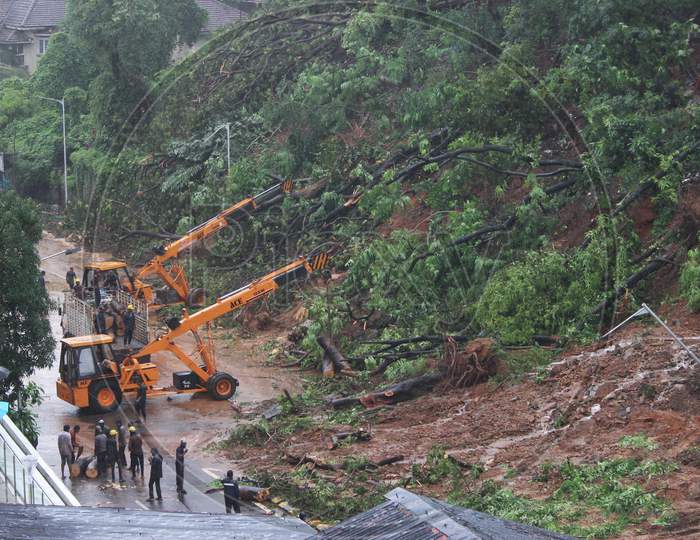 Firefighters and other workers clear debris from a landslide after heavy rainfall in Mumbai, India on August 6, 2020.