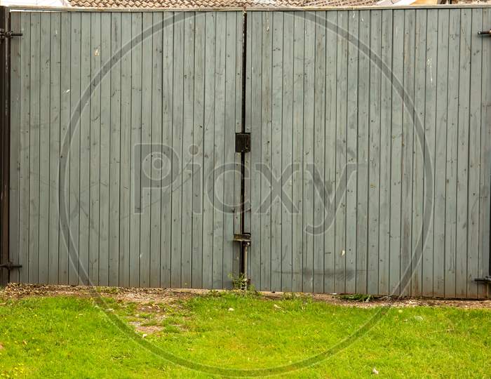 Large Gray Wooden Gate Closed And Locked.