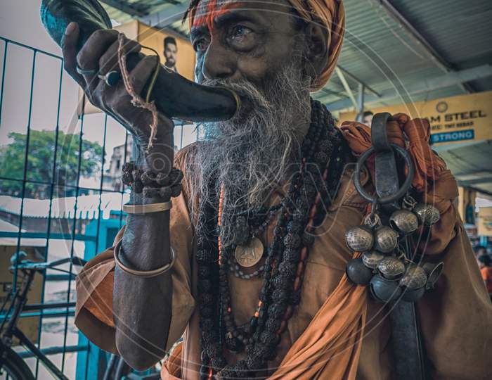 Tarakeswar, India – April 21 2019; An Unidentified Sadhu Blows Conch At Baba Taraknath Temple, A Hindu Temple Dedicated To God Shiva. The Temple Is An Atchala Structure Of Bengal Temple Architecture.