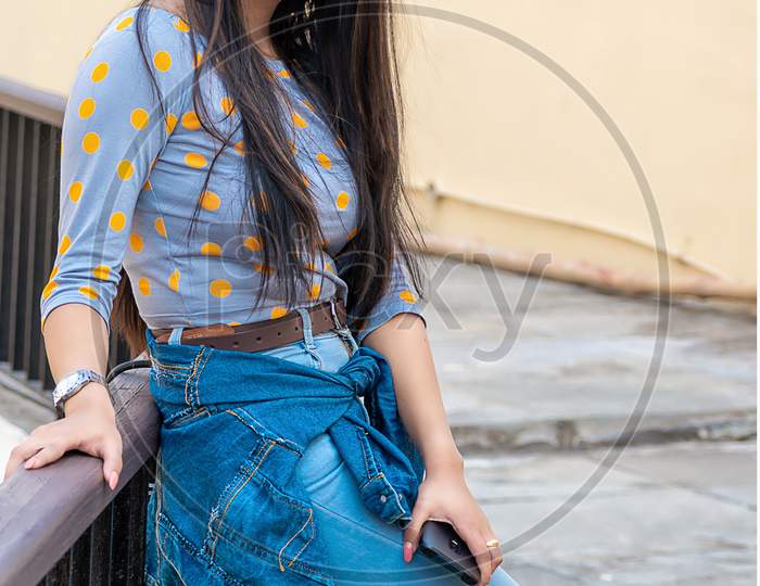 Fashion Portrait Of Beautiful Indian Girl Standing On Terrace Or Veranda. Cute Girl In A Western Outfit. Everyday Life Of A Beautiful Young Lady In Kolkata, India On December 2019